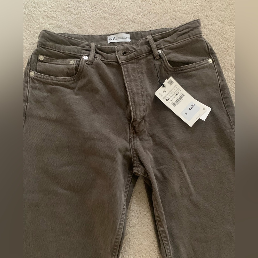 High waisted 5 pocket jeans. Side slit at hem. Front zip and metal button close